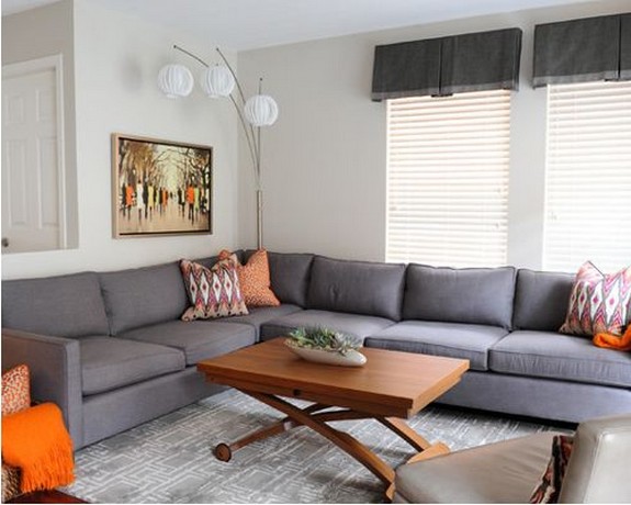 серый диван и оранжевые подушки