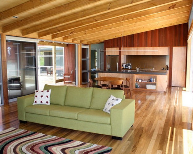 зеленый диван в коричневом интерьере